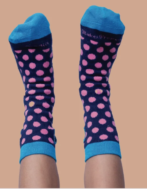 Pink and blue dotty socks shown as worn by a child
